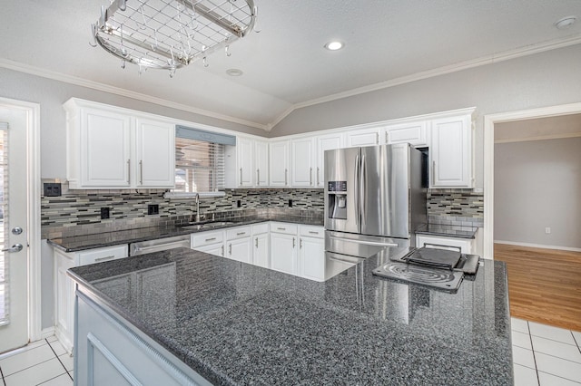 kitchen featuring stainless steel appliances, lofted ceiling, white cabinetry, and sink