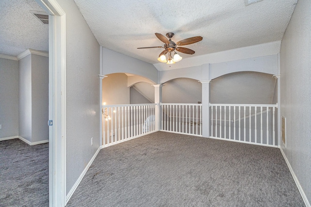 carpeted spare room with a textured ceiling, ceiling fan, and crown molding