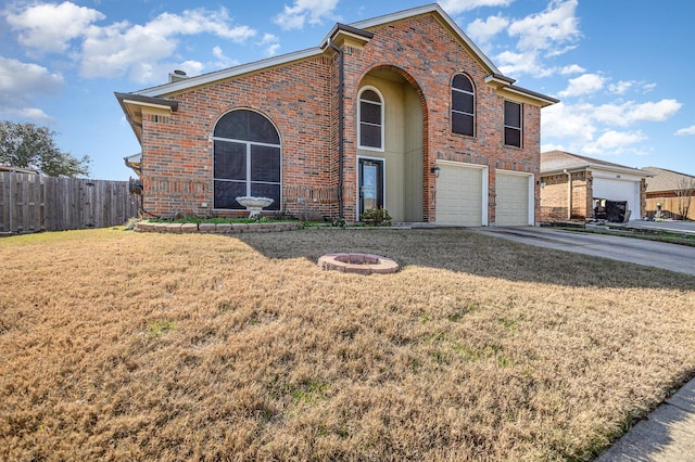 front facade with a front yard, a garage, and a fire pit