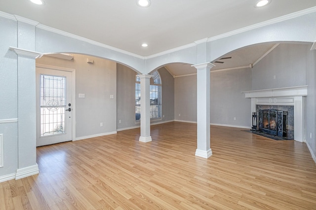 unfurnished living room with a high end fireplace, crown molding, and light hardwood / wood-style flooring