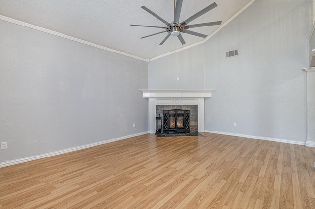 unfurnished living room with ceiling fan, light wood-type flooring, lofted ceiling, a high end fireplace, and crown molding