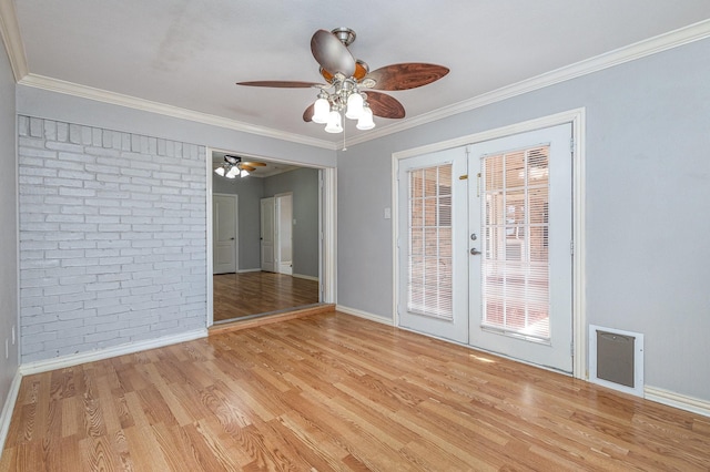 unfurnished room featuring light hardwood / wood-style floors, brick wall, crown molding, and french doors