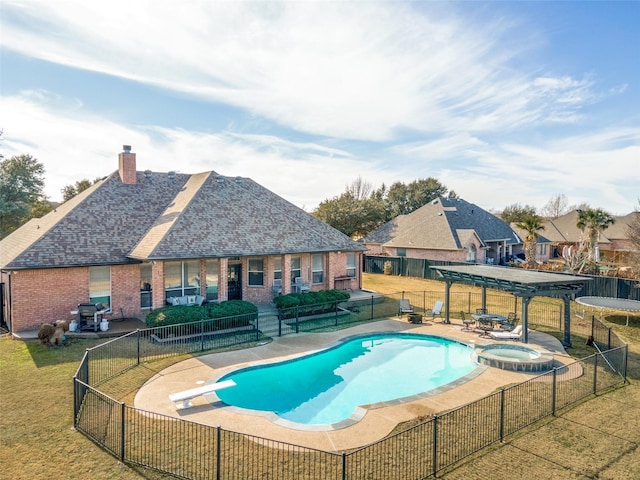 view of swimming pool with a diving board, an in ground hot tub, a pergola, and a yard