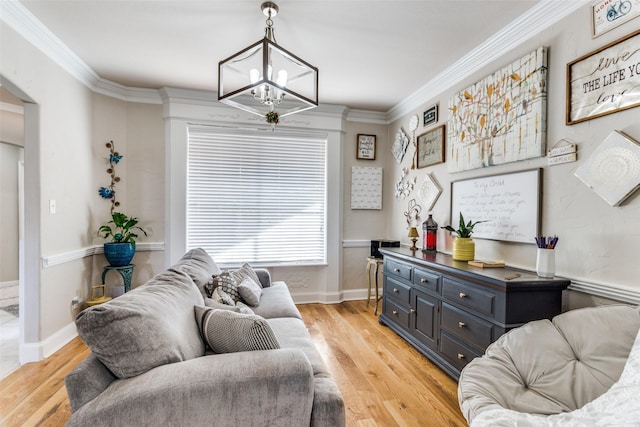 living room with light wood-type flooring, a chandelier, and ornamental molding