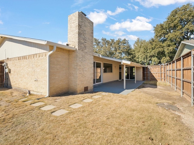 back of house featuring a patio and a lawn