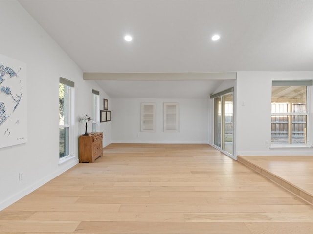 spare room featuring lofted ceiling and light hardwood / wood-style floors