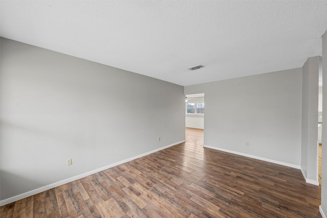 empty room featuring dark wood-type flooring and a textured ceiling