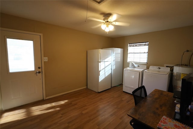 laundry area with ceiling fan, electric water heater, independent washer and dryer, and hardwood / wood-style floors