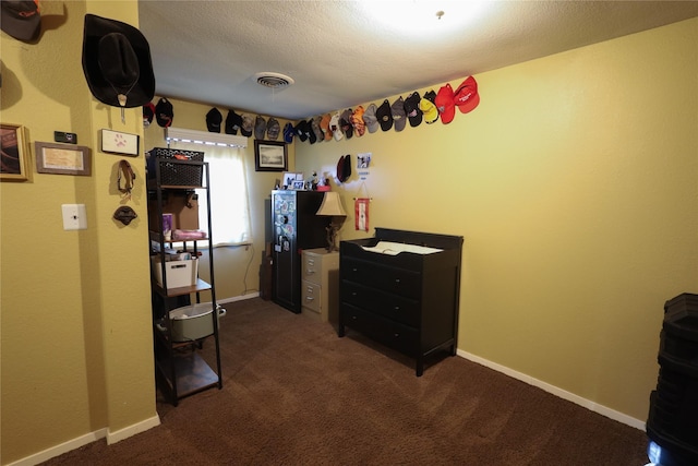 interior space featuring a textured ceiling and dark carpet