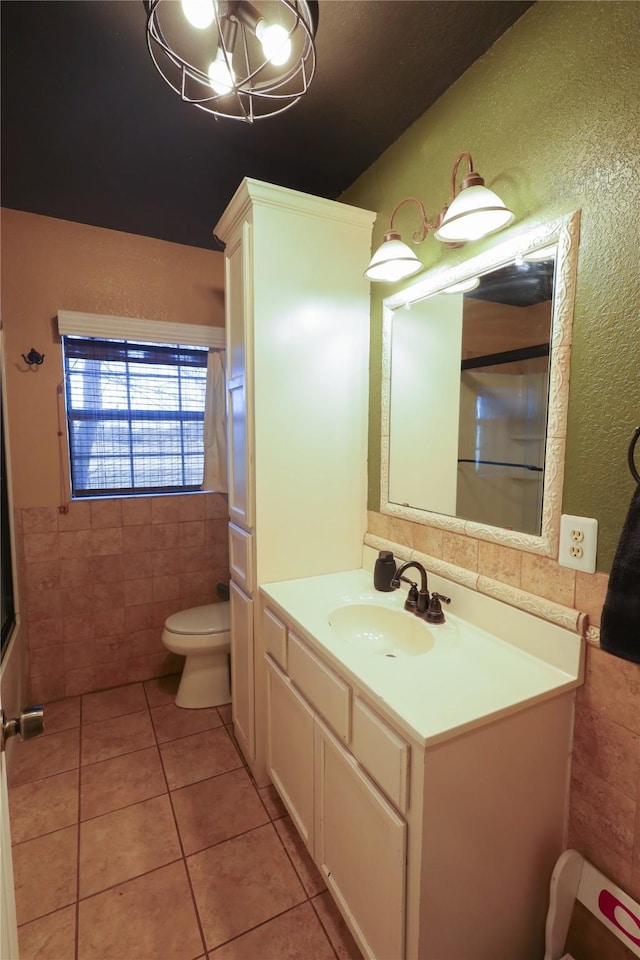 bathroom featuring toilet, tile walls, tile patterned floors, and vanity