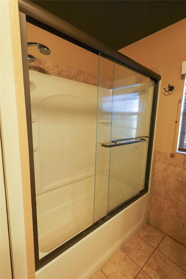 bathroom featuring bath / shower combo with glass door and tile patterned flooring