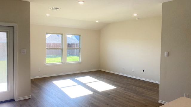 spare room featuring vaulted ceiling and dark wood-type flooring