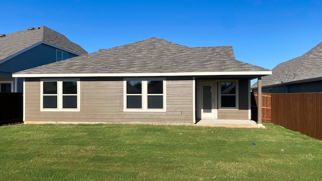 rear view of house featuring a yard