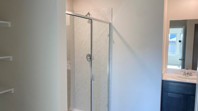 bathroom with a shower with shower door and vanity