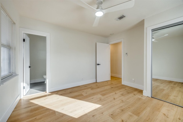 unfurnished bedroom with connected bathroom, light hardwood / wood-style flooring, ceiling fan, and a closet