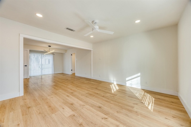 spare room with ceiling fan with notable chandelier and light hardwood / wood-style flooring