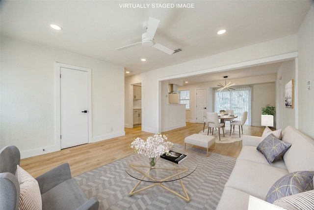 living room featuring light hardwood / wood-style flooring and ceiling fan