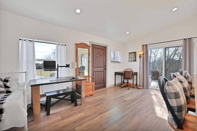 kitchen featuring appliances with stainless steel finishes, tasteful backsplash, light stone countertops, light hardwood / wood-style flooring, and beamed ceiling