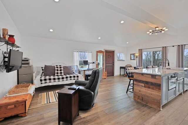 kitchen with light stone countertops, a breakfast bar, a large island with sink, and stainless steel appliances