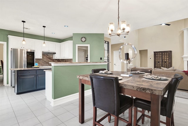 tiled dining room with an inviting chandelier