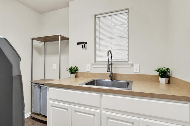 kitchen featuring white cabinets and sink