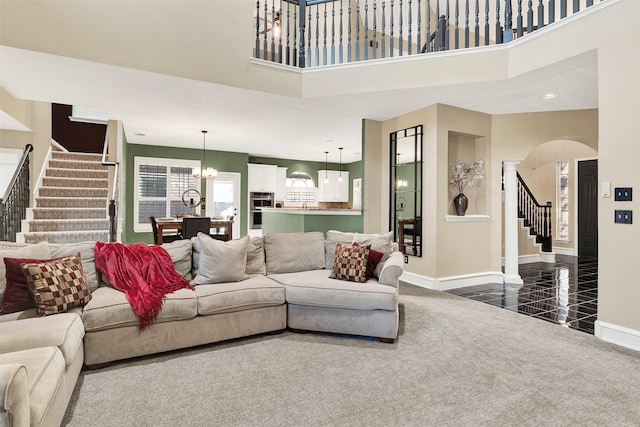 carpeted living room with a chandelier and a high ceiling