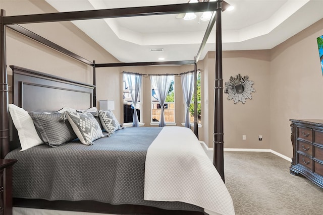 bedroom featuring carpet and a tray ceiling