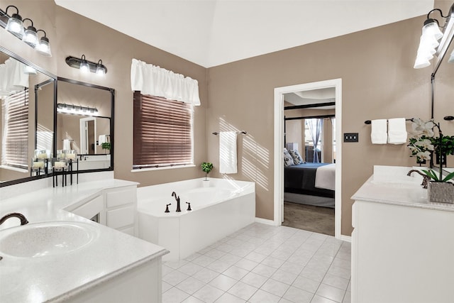 bathroom with a tub, vanity, and tile patterned flooring