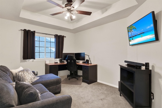 office space featuring ceiling fan, light carpet, and a raised ceiling