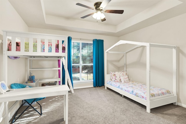 bedroom featuring ceiling fan, a raised ceiling, and carpet floors