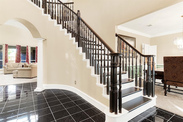 stairway featuring ornate columns and ornamental molding