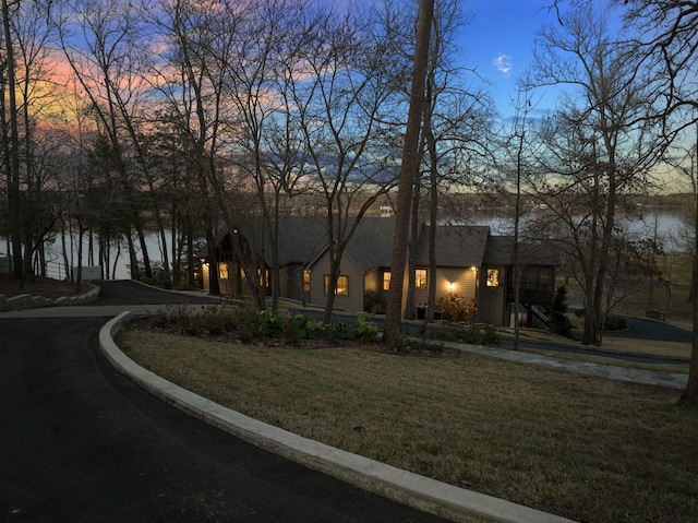 view of front of home with a yard and a water view