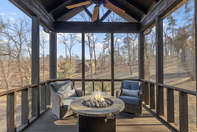 unfurnished sunroom featuring ceiling fan, a healthy amount of sunlight, and lofted ceiling