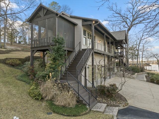 view of side of home with a garage and a sunroom