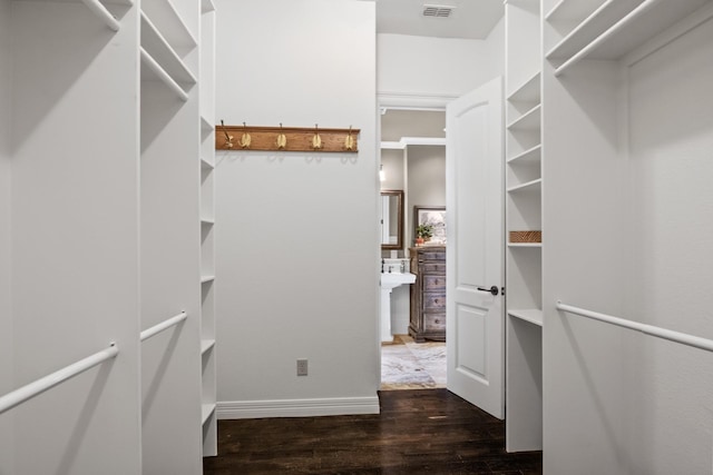 walk in closet with dark hardwood / wood-style flooring