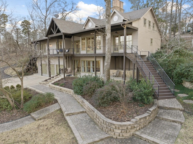 back of house with a garage and a balcony