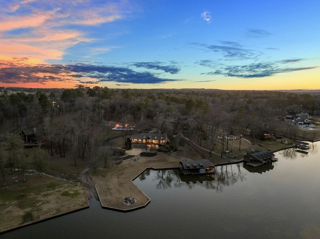 aerial view at dusk featuring a water view