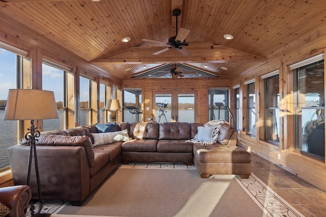 living room with lofted ceiling, ceiling fan, wooden walls, wood ceiling, and french doors