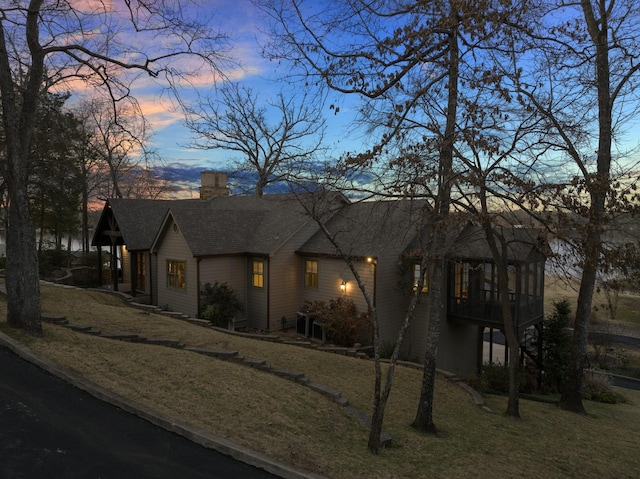 view of front of property with a yard and a sunroom