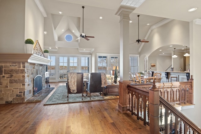 living room with a fireplace, ornamental molding, a towering ceiling, and ceiling fan