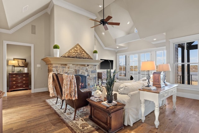 living room featuring crown molding, a fireplace, hardwood / wood-style floors, and high vaulted ceiling