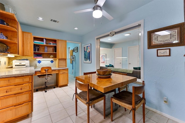 tiled dining room with built in desk and ceiling fan