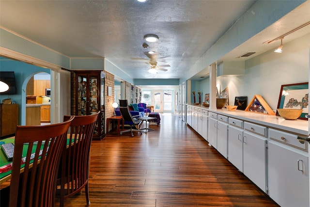 kitchen with ceiling fan, white cabinets, dark hardwood / wood-style flooring, and a textured ceiling