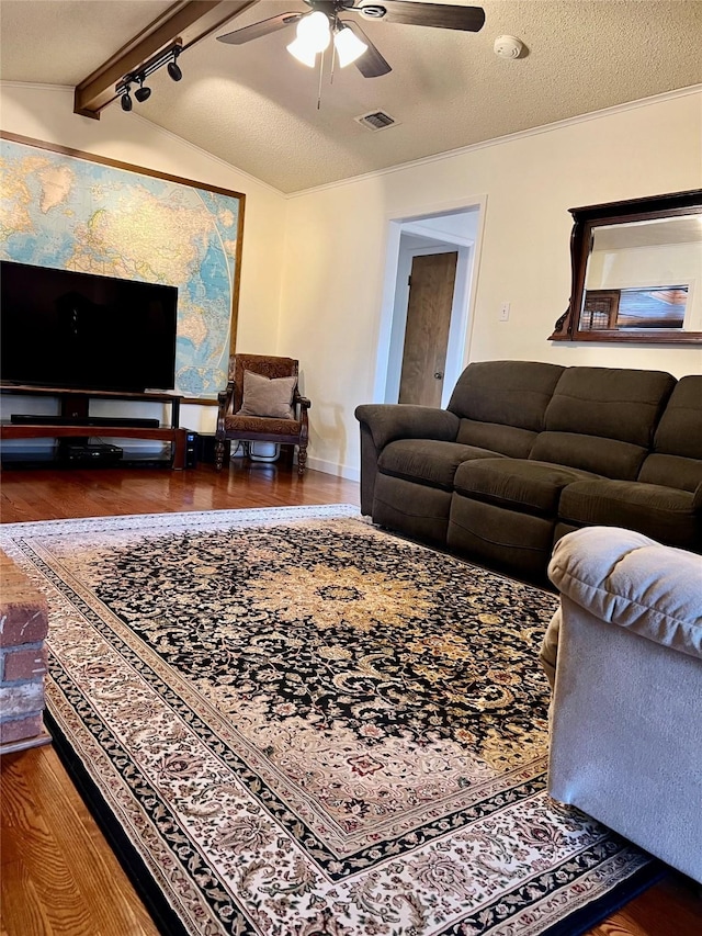 living room featuring rail lighting, ceiling fan, dark wood-type flooring, vaulted ceiling with beams, and a textured ceiling