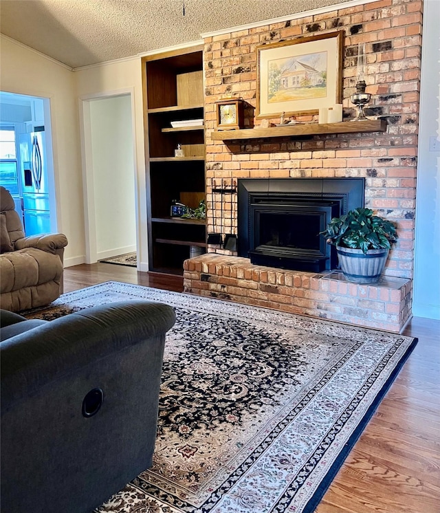 living room with a textured ceiling, lofted ceiling, a fireplace, and hardwood / wood-style floors