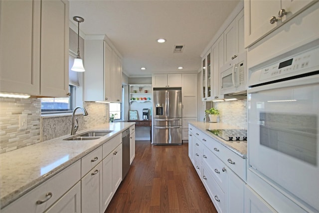 kitchen with decorative light fixtures, appliances with stainless steel finishes, sink, and white cabinetry