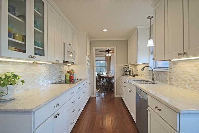 kitchen featuring black electric cooktop, dishwasher, hanging light fixtures, white cabinets, and sink