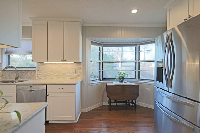 kitchen featuring stainless steel appliances, dark hardwood / wood-style flooring, light stone countertops, white cabinets, and sink