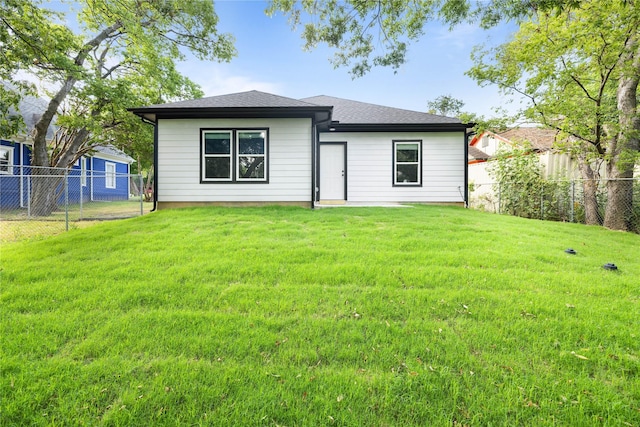 rear view of property with a lawn