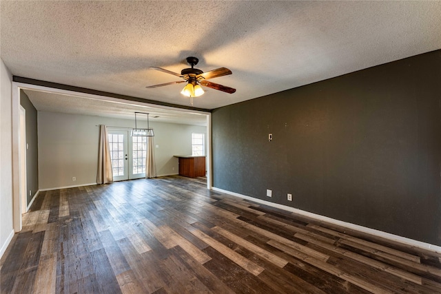 spare room with ceiling fan, french doors, dark hardwood / wood-style floors, and a textured ceiling